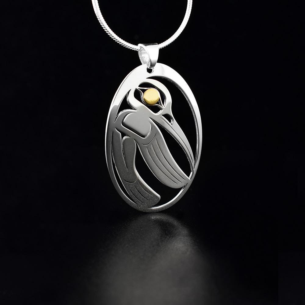 This cutout Hummingbird pendant is made from sterling silver and 18K gold with an oval shape. There are cutout designs in the pendant that depict the Hummingbird and the eyes of it are made from gold.