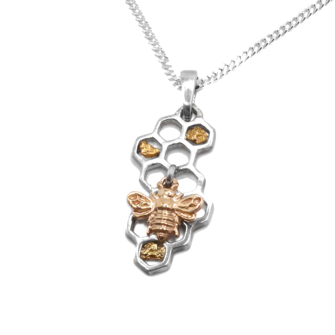 Sterling Silver Honeycomb 22K Gold Bee Pendant by Tom Gregorczyk. The pendant is in the shape of a beehive with 22k gold nuggets in certain areas representing the honey. The artist has attached a small bee made out of 10k gold to a loop in the center of the pendant. The bee is not secured and moves around when in motion.