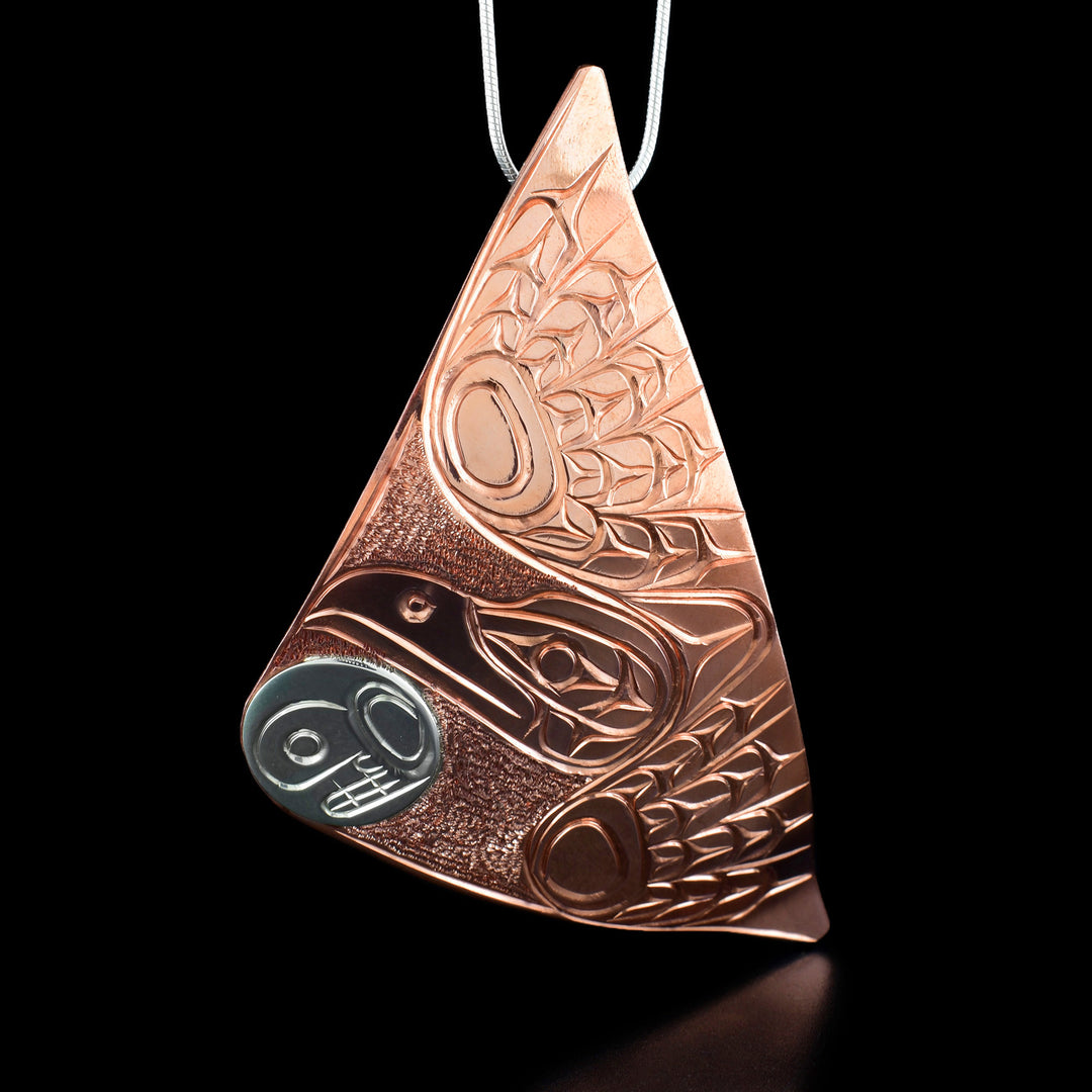 This Moon and Raven pendant is made from copper and sterling silver and has a large triangle shape. There is a gorgeous depiction of the Raven carrying the Moon carved into the pendant. The moon is made form sterling silver and the rest of the piece is made from copper.