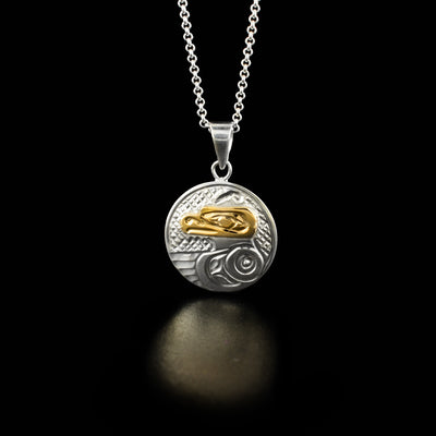 This round thunderbird pendant has the profile of a thunderbird's head made from 14k yellow gold facing the left in the center. Underneath the head is a spread out wing.