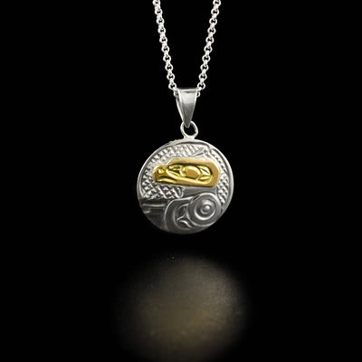 This round owl pendant has the profile of an owl's head made from 14k yellow gold facing the left in the center. Underneath is the owl's large, spread out wing.