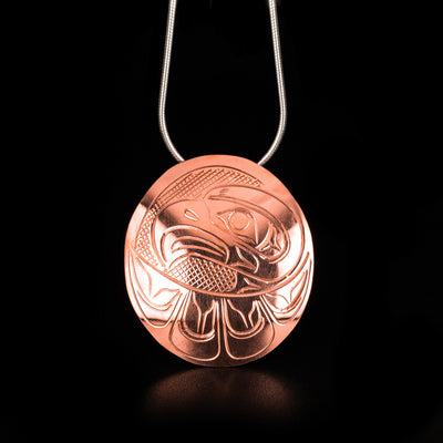 This Oval Eagle Pendant is handmade by Kwakwaka'wakw artist, John Lancaster. He has used copper to create this piece. The pendant measures approximately 1.5" x 1.4". There is a hidden bail in the back. The chain is not included. The Eagle Legend Represents: POWER, INTELLIGENCE, VISION.