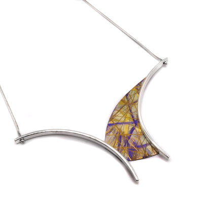 Gold Titanium Arch Necklace by Jean-Yves Nantel. Anodized gold titanium is an asymmetrical shape in the center of the pendant with two sterling silver accents on either side resembling the shape of an arch.