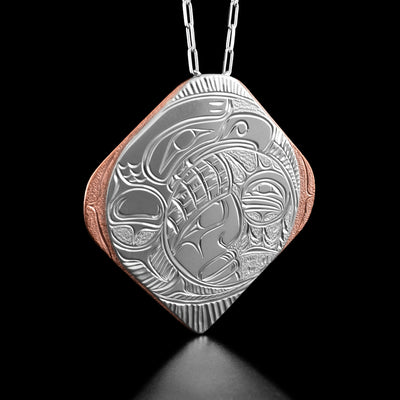 This thunderbird necklace has the profile of a thunderbird's head and wing surrounding a small circle with a male chief's face in it. Beside the chief is a small forest and the sun.