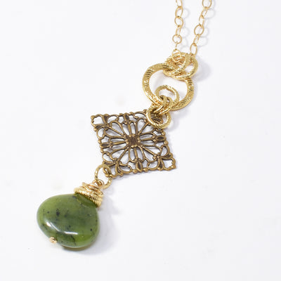 Antique Brass BC Jade Filigree Necklace handcrafted by artist Karley Smith. Pendant made of brass, BC jade and gold-plated adornments and wire. Gold-filled chain included. Pendant measures 2.13" x 0.81" including bails and chain is 24" long.