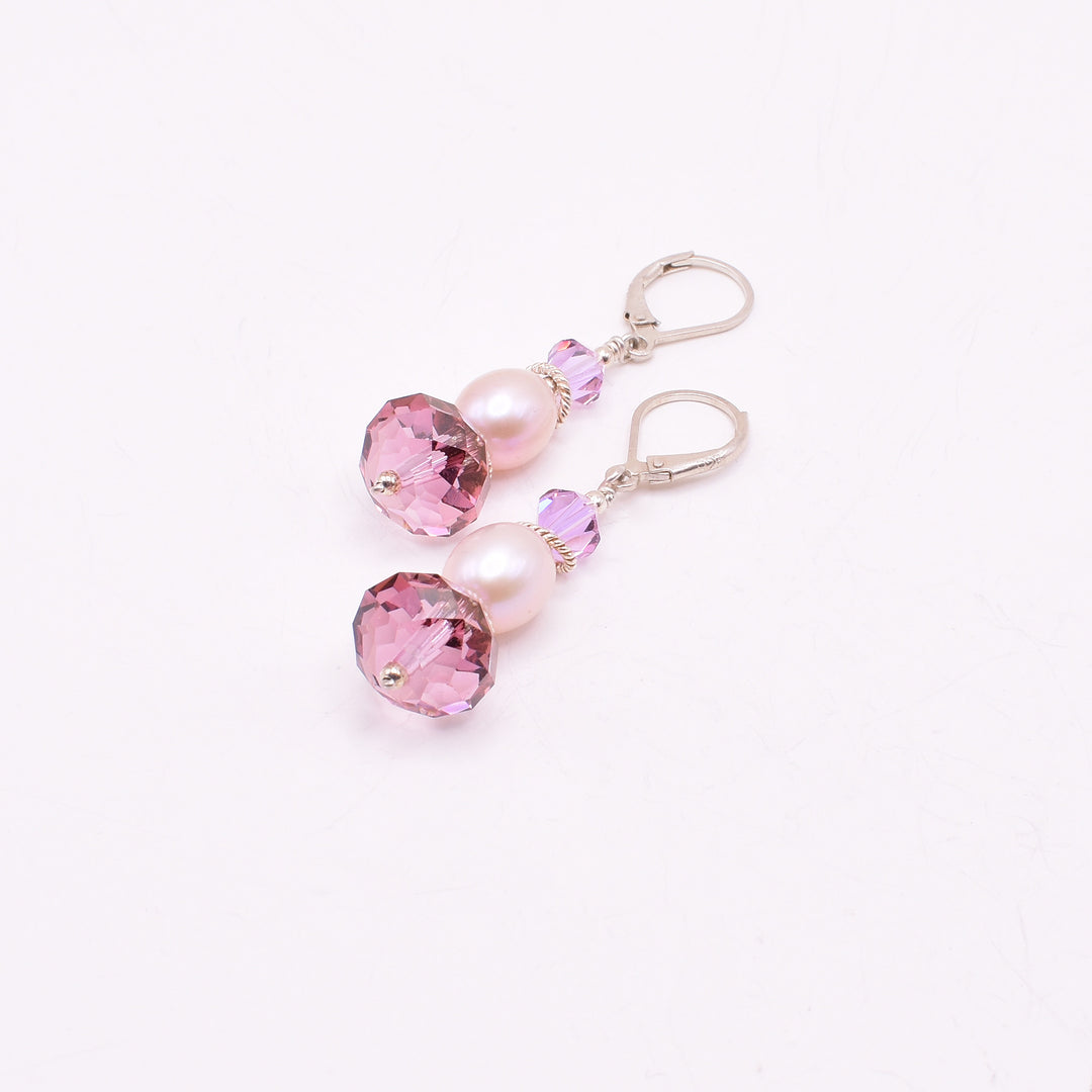 Charming lever back earrings handcrafted by artist Karley Smith. Made of Swarovski crystals in Antique Pink, sterling silver and freshwater pearls. Ear hooks are sterling silver. Each earring measures 1.85" x 0.50" including hook.