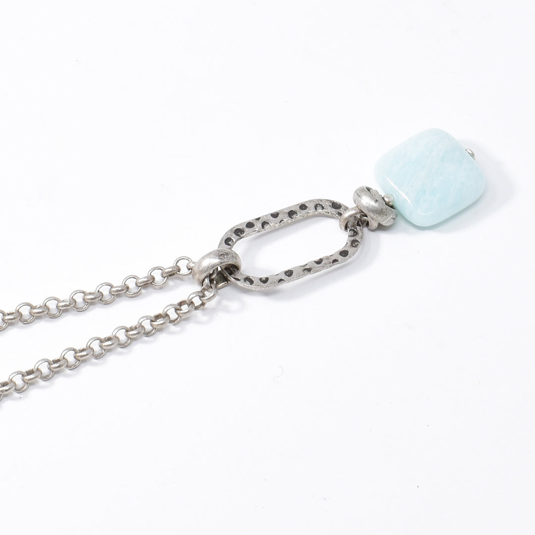 This amazonite necklace with pendant is made form sterling silver, antique silver and amazonite gemstone. The rolo style chain is made from antique silver and the pendant has a large, textured jump ring with a square gems on the end. The gem has a light turquoise color to it.