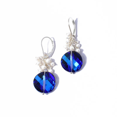 Sterling silver lever-back earrings handcrafted by artist Debra Nelson. Each earring consists of a round Bermuda Blue Swarovski Crystal with a cluster of pearls above. Each earring measures 1.50" x 0.56" including hook.