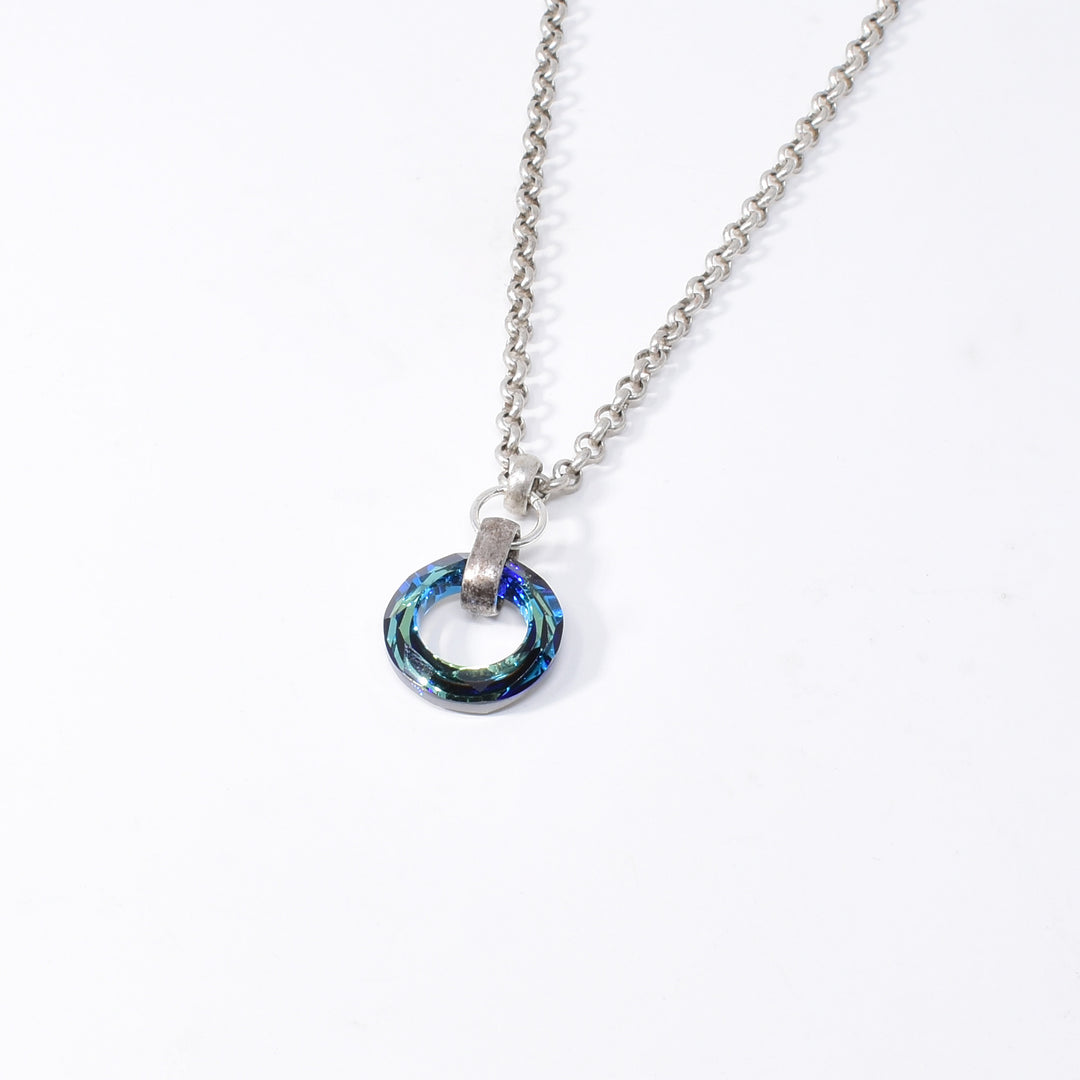 Stunning Bermuda Blue Crystal Ring Pendant Necklace handcrafted by artist Karley Smith. Made of Bermuda Blue Swarovski Crystal, antiqued silver and sterling silver. Antiqued silver chain included. Pendant measures 1.40" x 0.80" including bail and chain is 20" long.