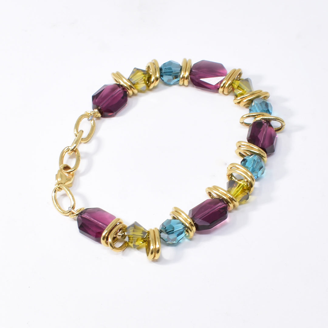 Blue, Green and Purple Swarovski Crystal Bracelet handcrafted by artist Karley Smith. She has used Swarovski Crystal, gold-plated rings and gold-filled finishings to create this bracelet. Swarovski crystals are in the colours: Indicolite Satin, Lime Satin and Amethyst. Bracelet is 7.5" long with 0.5" extender.