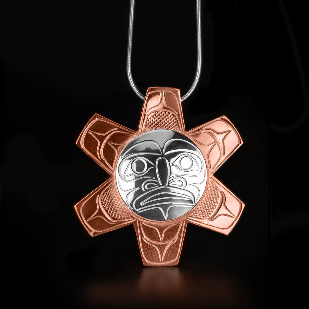 Stunning Copper and Silver Sun Pendant hand-carved by Kwakwaka'wakw artist John Lancaster. Made of sterling silver and copper. Pendant measures approximately 2" in diameter. Hidden bail on back. Chain not included.