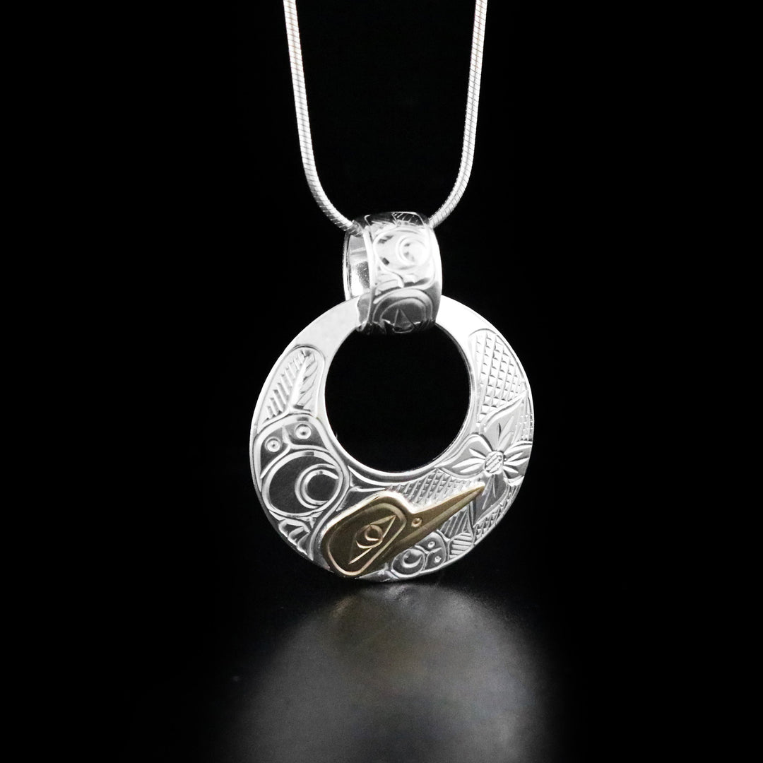 Dazzling Cut Out Hummingbird Pendant with Carved Bail hand-carved by Cree and Coast Salish artist Richard Lang. Made of 14K gold and sterling silver. Pendant measures 1.6" x 1.2" including bail. Chain not included.