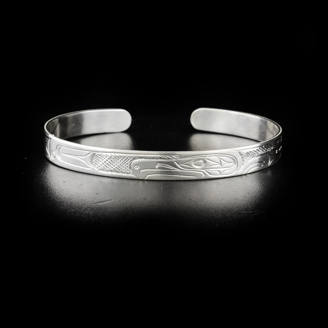 This image shows the eagle bracelet head-on with the head of the eagle in the center facing the left. To the right and left are carvings representing the animal's wings and body.