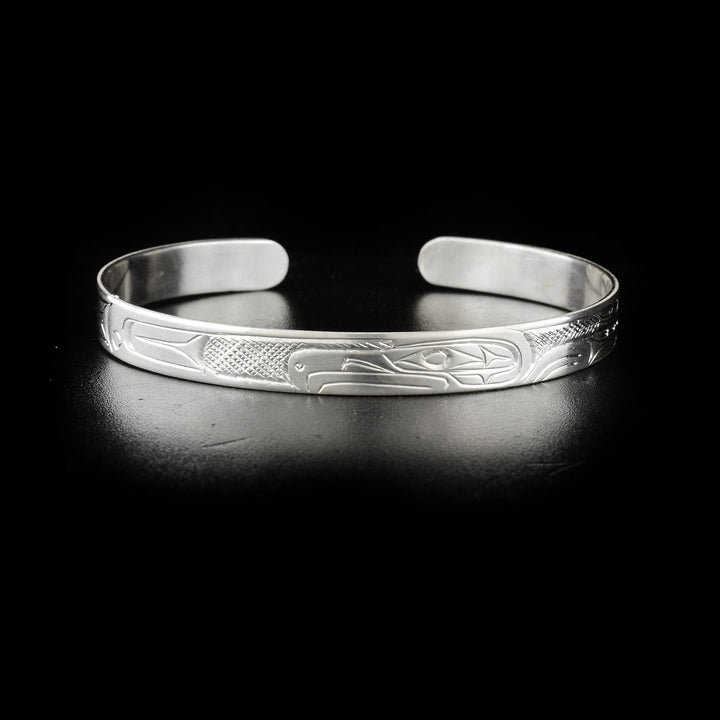 This image shows the eagle bracelet head-on with the head of the eagle in the center facing the left. To the right and left are carvings representing the animal's wings and body.