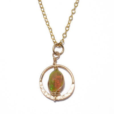 Dazzling Ethiopian Opal in Ring Pendant Necklace handcrafted by artist Debra Nelson. She has used 14K gold fill wire, a 14K gold fill ring and Ethiopian opal to create the pendant. Half of ring is hammered. 14K gold fill chain included. Pendant measures 0.94" x 0.56" including bail. Chain is 16" long with 2" extender.