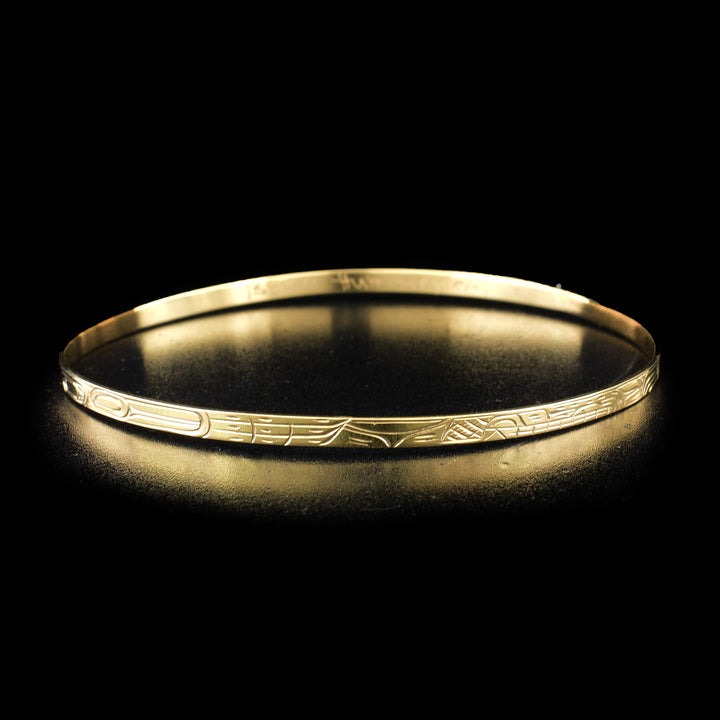 Elegant orca, hummingbird and wolf bangle hand-carved by Kwakwaka'wakw artist Victoria Harper. Made of 14K gold. Bracelet is 9" long and has width of 0.13".
