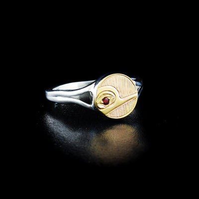 Dazzling hummingbird circle ring hand-carved by Haisla artist Hollie Bartlett. Made of 14K gold and sterling silver. Garnet in eye of hummingbird. Circular face of ring is 0.38" in diameter. Size 7.5.