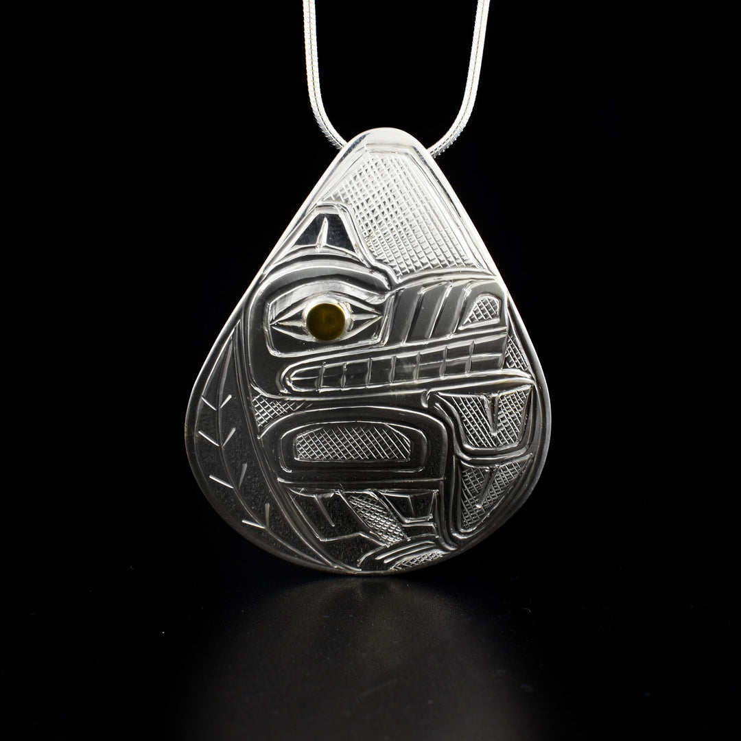 Teardrop wolf pendant hand-carved by Heiltsuk artist Reg Gladstone. Made of 14K gold and sterling silver. Pendant measures 2" x 1.5". Hidden bail on back. Chain not included.