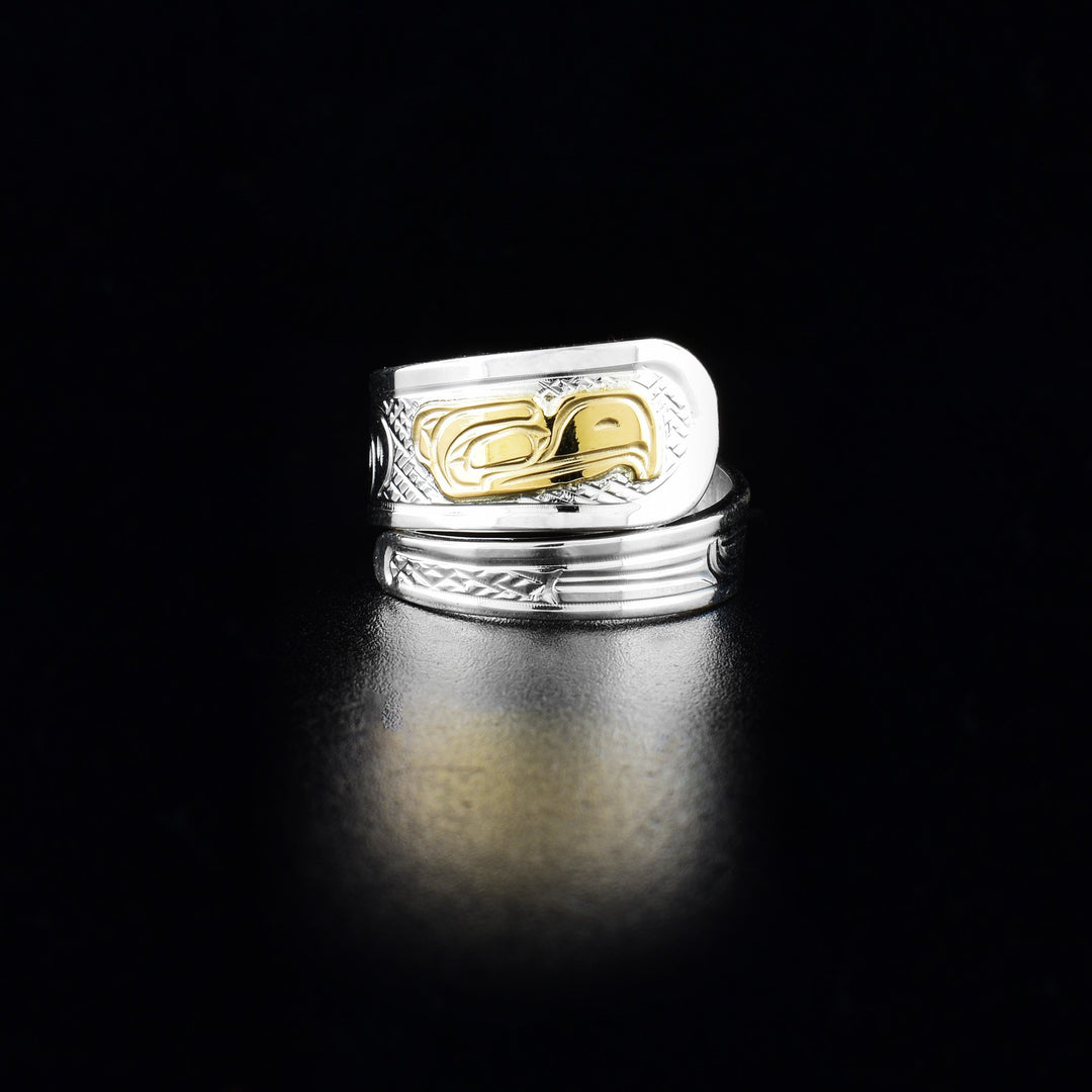 This Eagle wrap around ring is made from sterling silver and 14K gold. The band is tapered and wraps around the finger twice. There is a depiction of the Eagle carved into the band and the head of the Eagle is made from 14K gold.