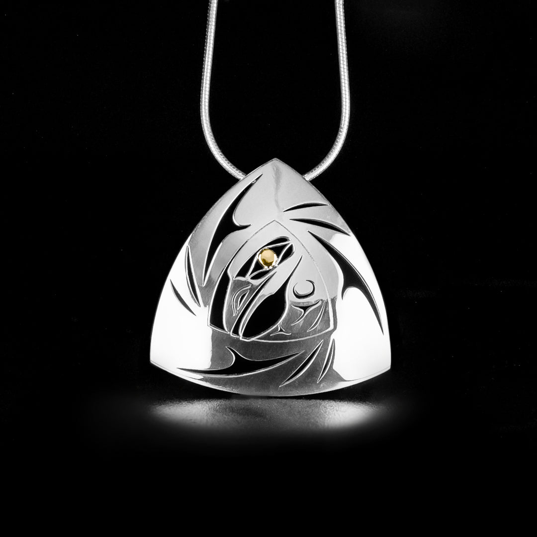 This gorgeous Raven pendant is made from sterling silver and 18K gold. The pendant is triangle shaped with cutout designs sround the center of the pendant. In the center there is a cutout depiction of the raven that has been cast into the piece.