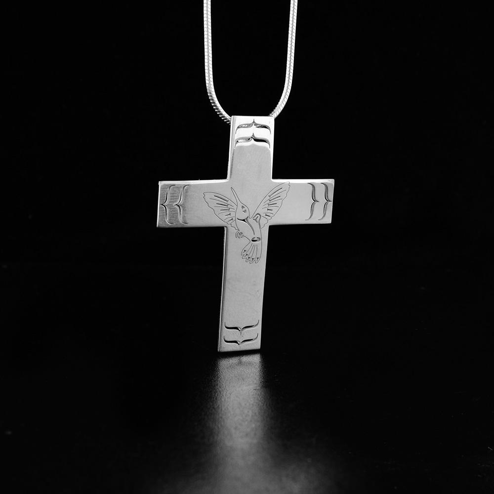 This Hummingbird pendant is made from sterling silver and is shaped like a large cross. There is a depiction of the Hummingbird cast into the surface of the pendant.