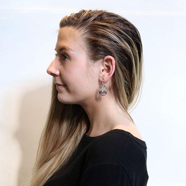 These dangling Frog earrings are made from sterling silver and have circle shaped hangs. There are cutout depictions of the Frog that have been cast into the hangs.