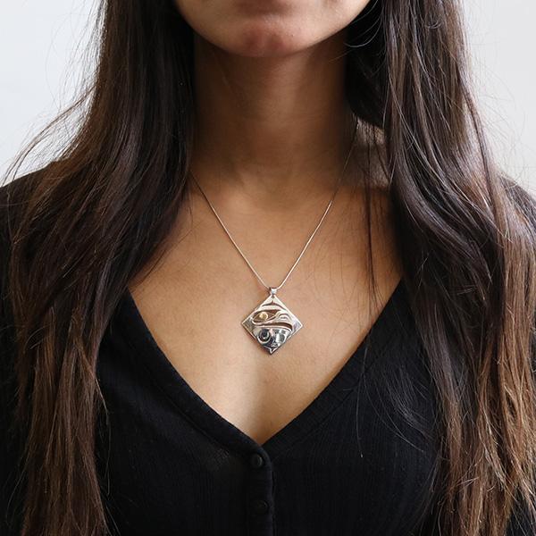This Eagle pendant is made from sterling silver and 18K gold, it also is large and diamond shaped. There are cutout designs in the pendant that depict the Eagle and the eye of the Eagle is made from 18K gold.