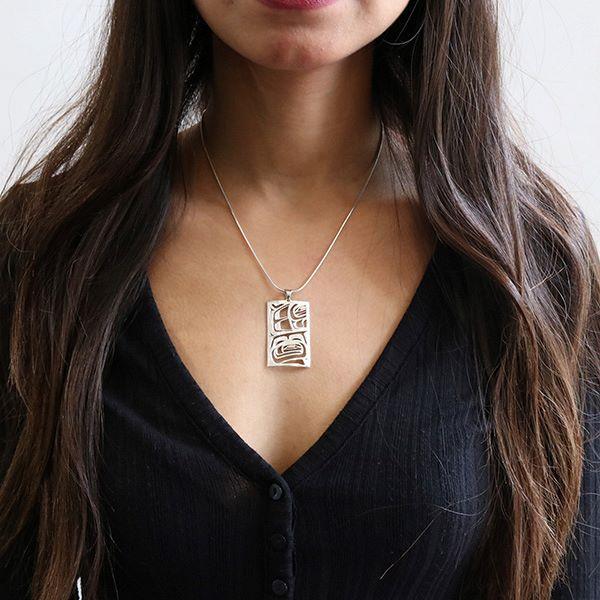 This gorgeous Raven pendant is made from sterling silver and 18K gold. It is rectangle shaped and has cutout designs that depict the Raven on the surface of the pendant. The eyes of the pendant are made from 18K gold.