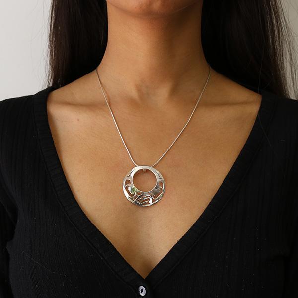 This Eagle pendant is made from sterling silver and 18K gold with a large, circle shape with a circle cutout in the middle. There are also cutout designs in the pendant that depict the Eagle; the eye of the Eagle is made form 18K gold.