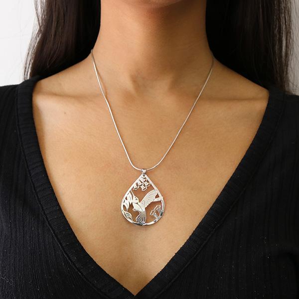 This elegant Hummingbird pendant is made from sterling silver and 18K gold and is teardrop shaped. There is a cutout design depiction the Hummingbird that has been cast into the pendant. The eye of the Hummingbird is made from 18K gold.