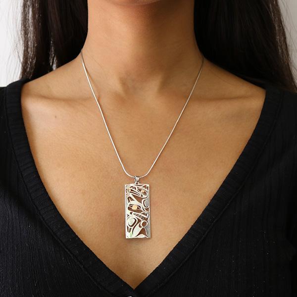 This Raven and Wolf pendant is made from sterling silver and 18K gold with a rectangle shaped. There are cutout depictions of the Raven and the Wolf made in the pendant and the eyes of the Legends are made with 18K gold.