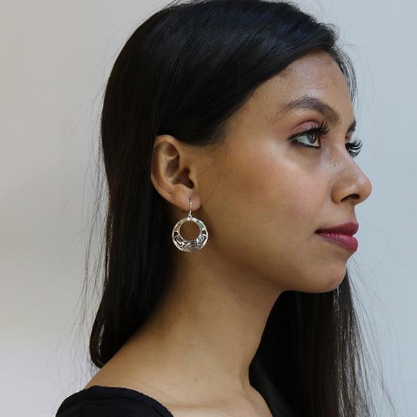 These Eagle earrings are made from sterling silver and have circle shaped hangs. There is a large, circle cutout in the middle with cutout designs of the Eagle cast into the perimeter of the hangs.