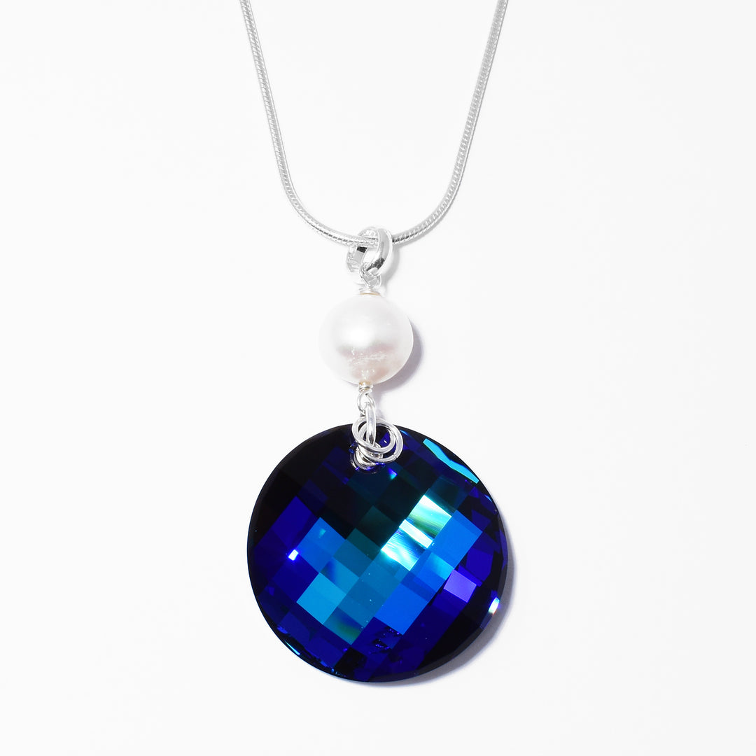 Large Bermuda Blue Twist Pendant with Pearl handcrafted by artist Debra Nelson. Made of Bermuda Blue Swarovski Crystal, freshwater pearl and sterling silver. Pendant measures approximately 2" x 1" including bail. Chain is not included.