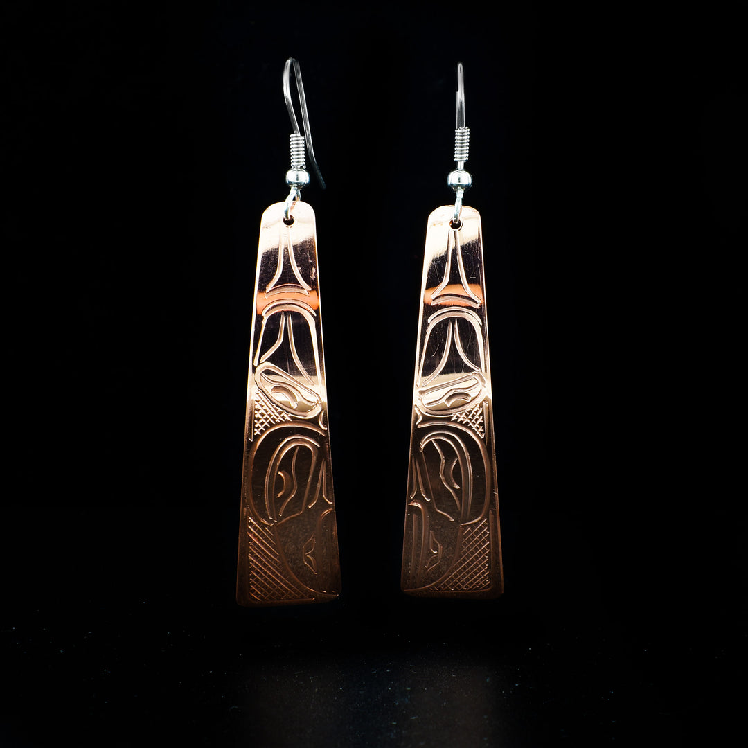 Long Copper Raven Earrings hand-carved by Kwakwaka'wakw artist John Lancaster. They are made of copper and have sterling silver ear hooks. Each earring measures 2.65" x 0.50" including hook.