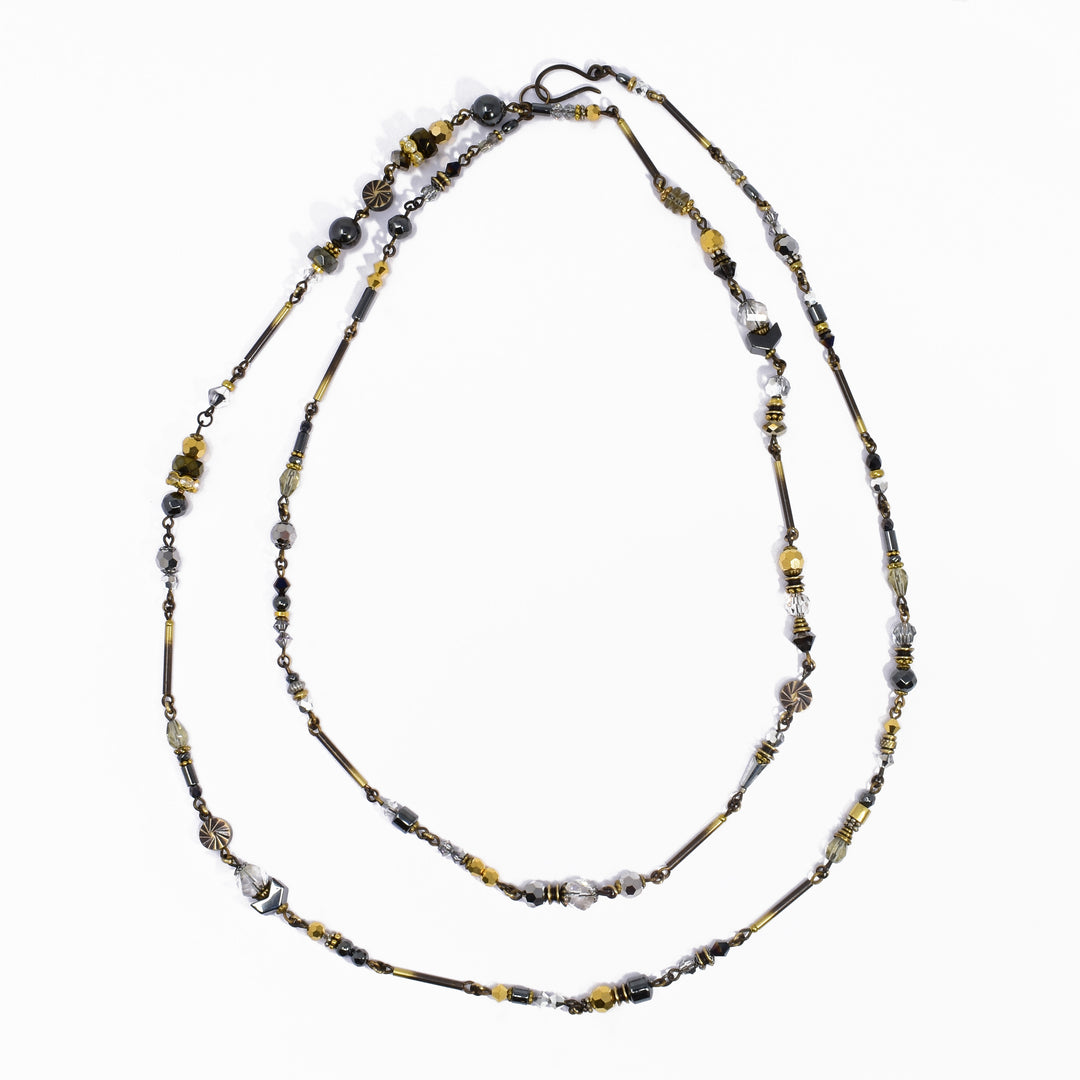 Made of Austrian crystal, handworked brass, hematine and glass. 46" long.