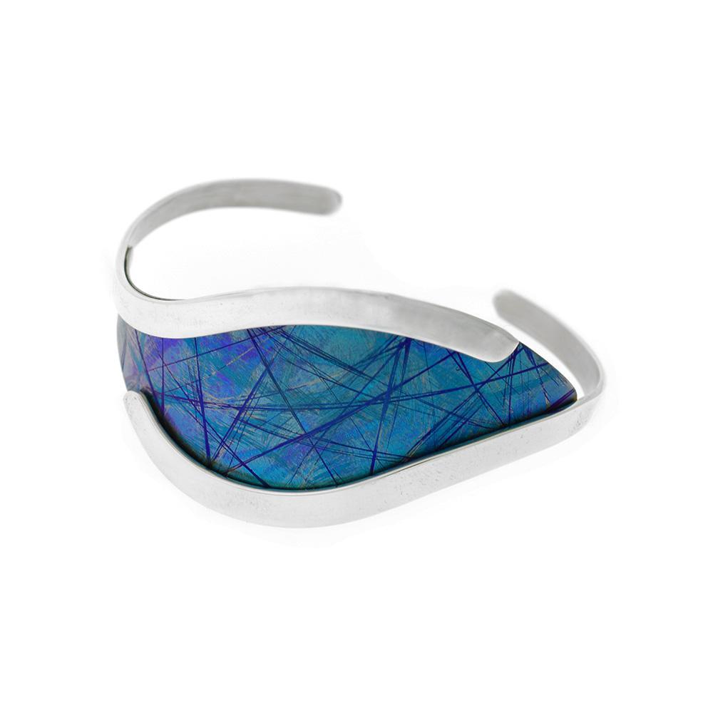 This titanium bracelet is made from sterling silver and anodized titanium. The piece has a wide, blue titanium piece at the top of the bracelet and has curvy, silver accents for the rest of the cuff bracelet.