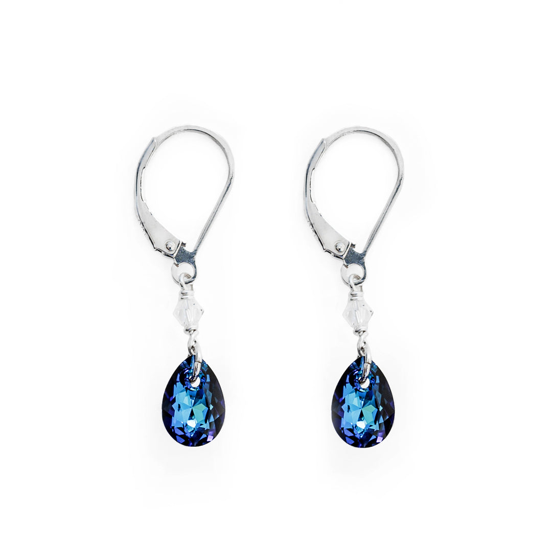 Dainty lever back earrings handcrafted by artist Debra Nelson. Made of Bermuda Blue Swarovski Crystal, clear Swarovski Crystal and sterling silver. Each earring measures 1.25" x 0.25" including hook.