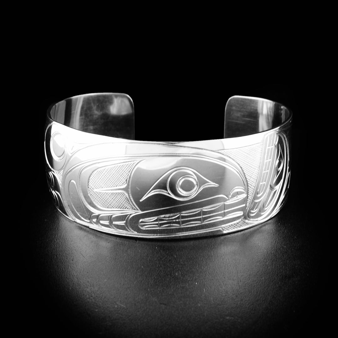 This sterling silver cuff bracelet has a wide, tapered band with a depiction of the Orca carved into the surface of it.