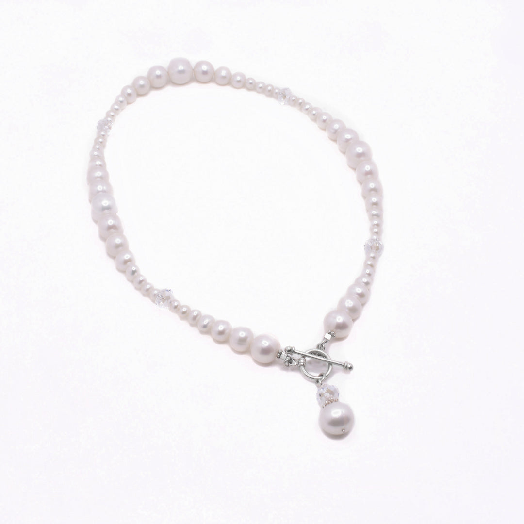 Unique Pearl Necklace handcrafted by artist Karley Smith. She has used sterling silver, freshwater pearl and Swarovski Crystal to create this piece. Necklace is 17" long and closes in front with toggle clasp.