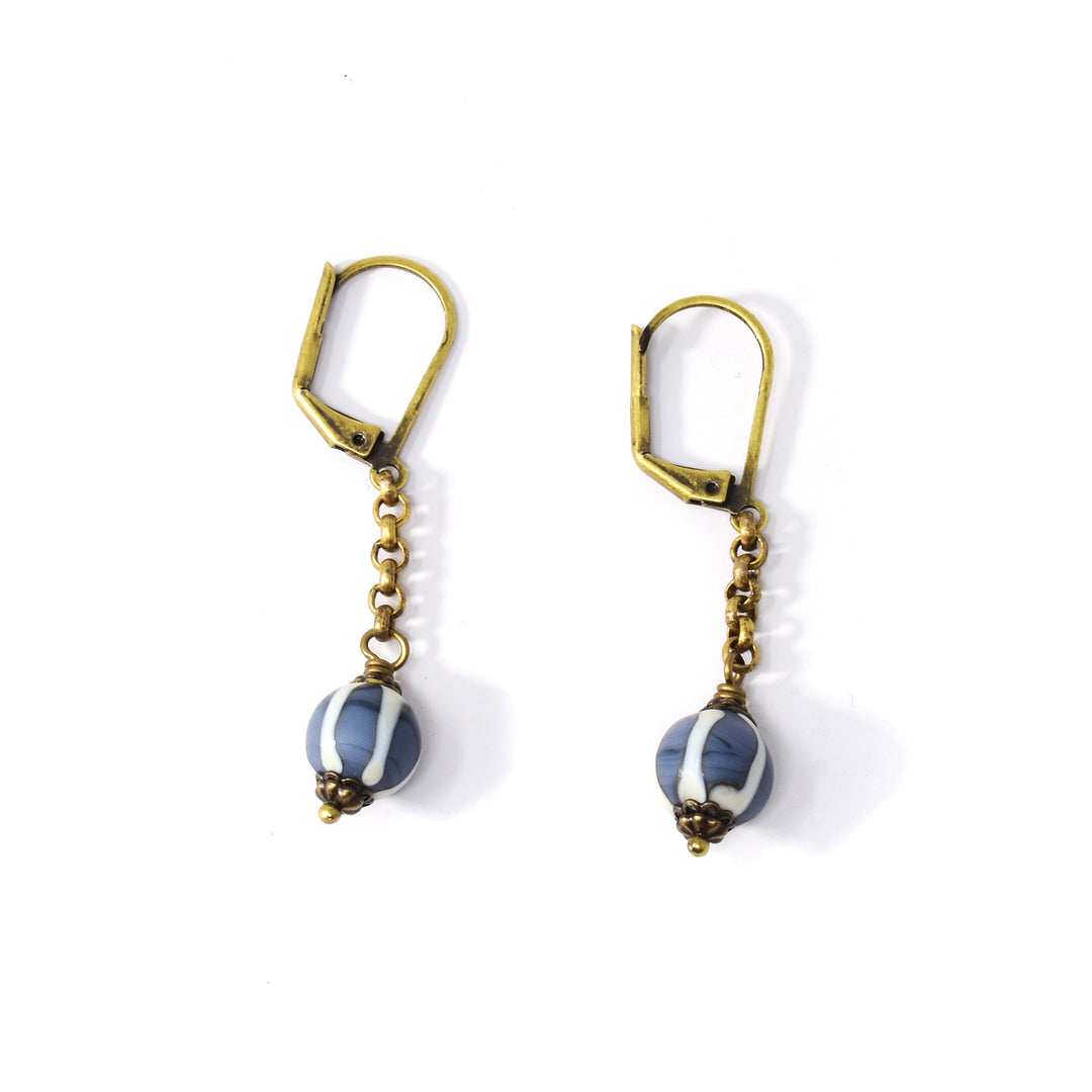 These dangling glass earrings are made from antiqued brass and hand worked, lampworked glass beads. The beads are attached to rustic looking brass chains and have coastal, blue and white striped designs on them.