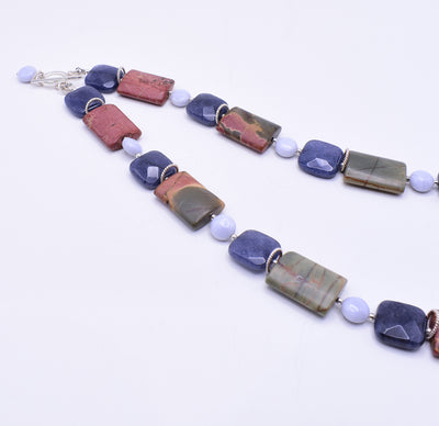 Unique necklace handcrafted by artist Karley Smith. She used Picasso jasper, blue jade, blue lace agate and sterling silver to create this piece. Necklace is 18" long.