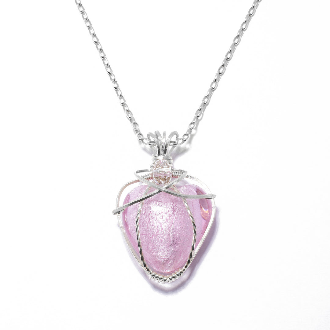 Pink Murano Glass Heart Pendant Necklace handcrafted by artist Debra Nelson. She has used sterling silver wire, a pink murano glass bead and a Swarovski Crystal bead to create the pendant. Sterling silver chain included. Pendant measures 1.31" x 0.88" including bail. Chain is 18" long.