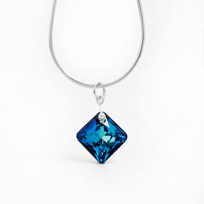 Princess Cut Bermuda Blue Swarovski Crystal Pendant handcrafted by artist Debra Nelson. Made of sterling silver and Bermuda Blue Swarovski Crystal. Pendant measures 1" x 0.63" including bail. Chain not included.