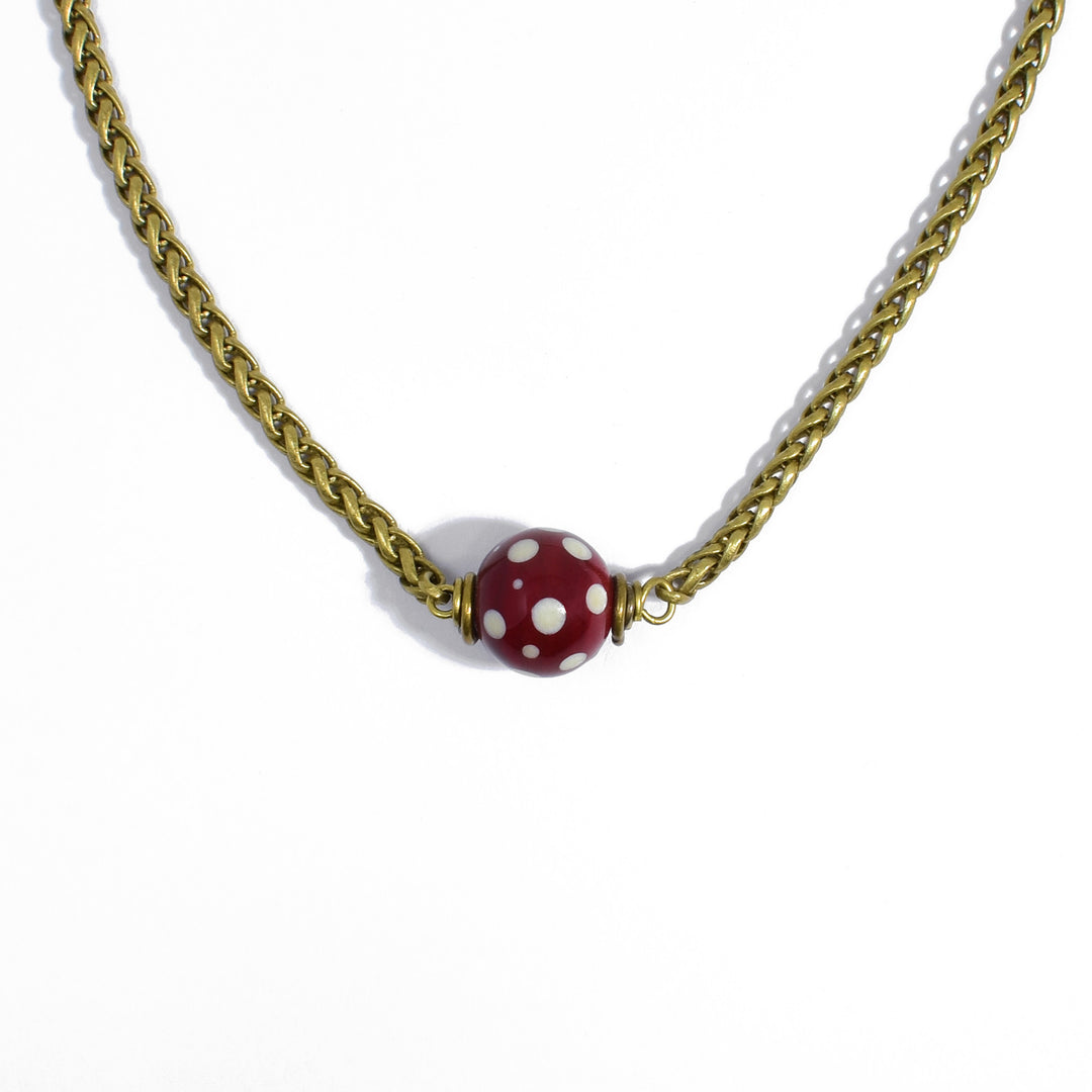 Central, handmade lampworked glass bead is set in place. Red with white polka dots. Brass wheat chain and wiring. Bead is 0.44" in diameter. Necklace is 15" long with 2.5" extension.