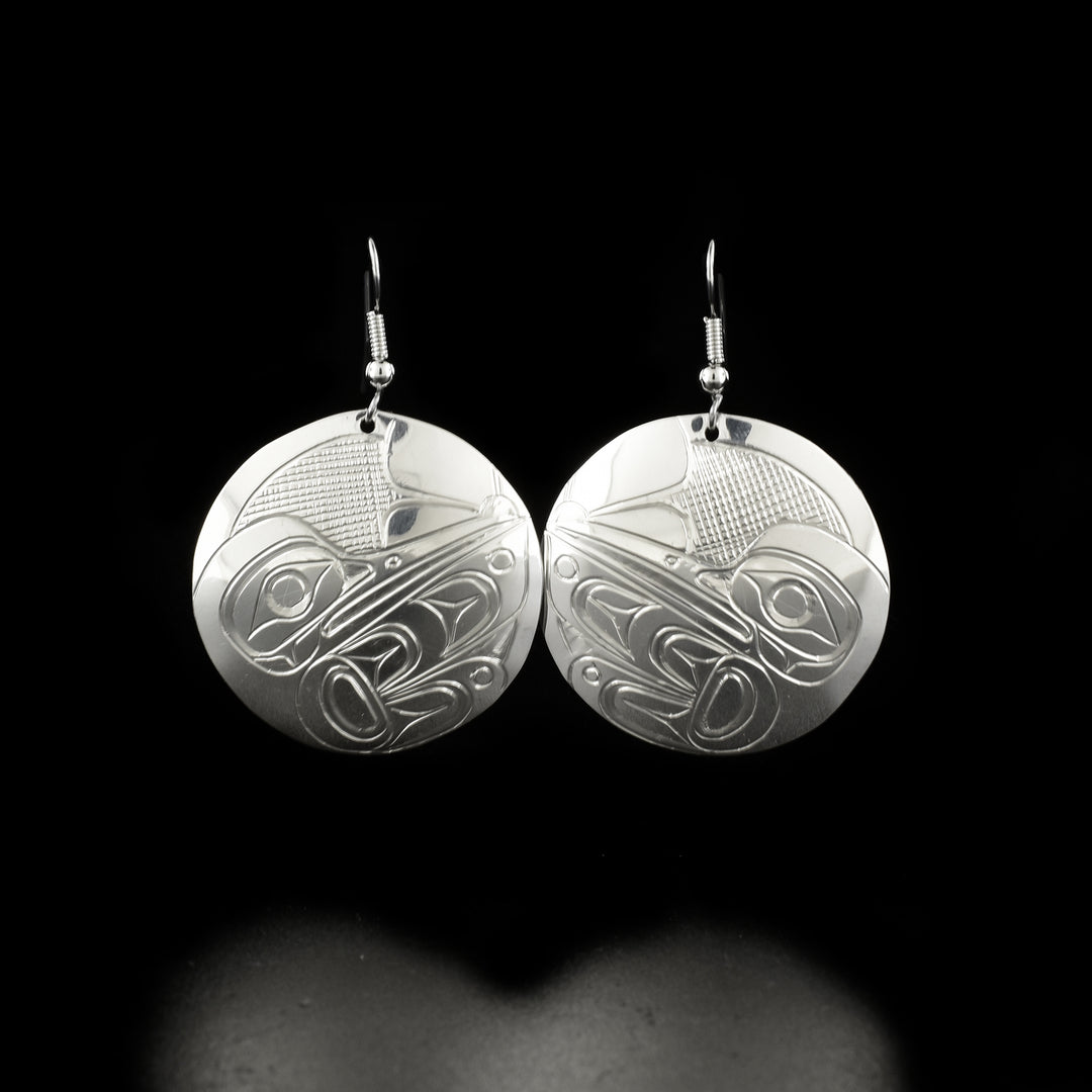Delicate round hummingbird earrings hand-carved by Kwakwaka'wakw artist Don Lancaster. Made of sterling silver. Each earring measures 2" x 1.25" including hook.