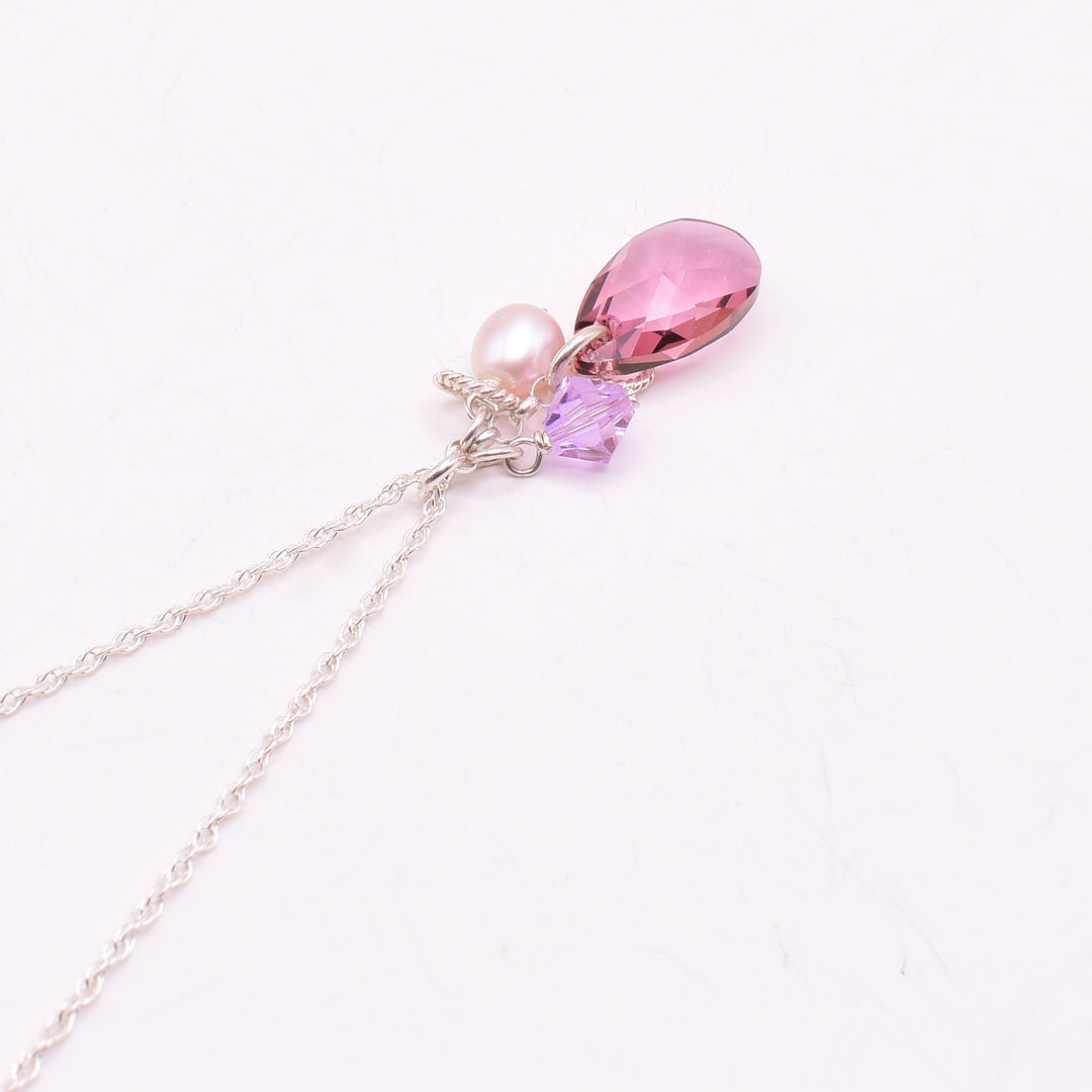 Silver Antique Pink and Pearl Pendant Necklace handcrafted by artist Karley Smith. Main crystal is a Swarovski crystal in Antique Pink, smaller crystal is also Swarovski. Karley has used sterling silver, Swarovski Crystal and freshwater pearl to create the pendant. Sterling silver chain included. Pendant measures 1.20" x 0.60" including bail and chain is 18" long.