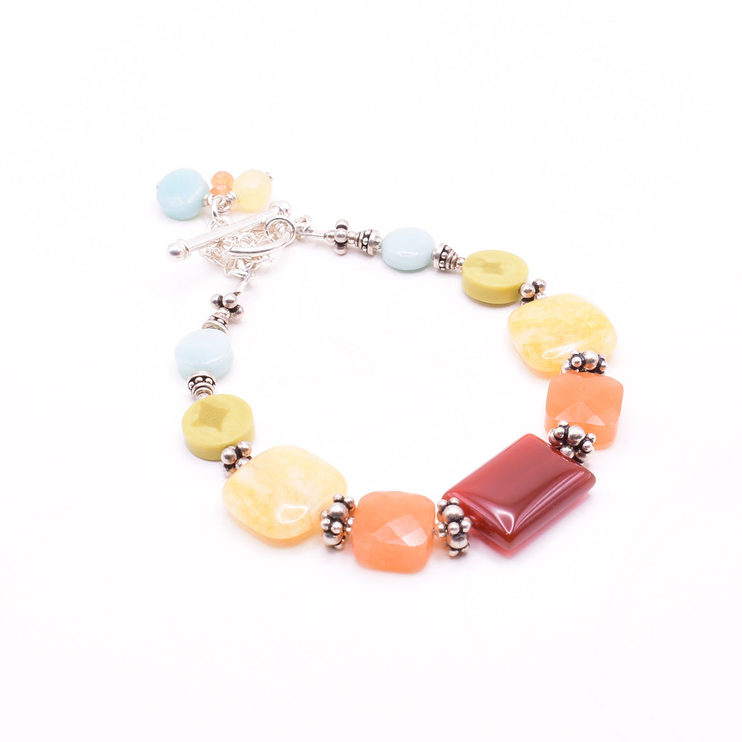 Stunning Silver Colourful Gemstone Bracelet handcrafted by artist Karley Smith. Made of carnelian agate, yellow jade, yellow turquoise, amazonite, sterling silver and oxidized silver. Bracelet closes with a toggle clasp and a safety chain adds an extra element of security. Bracelet is 7" long when clasped shut.