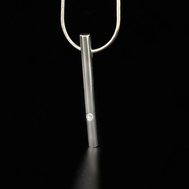 This elegant sterling silver and cubic zirconia necklace has a solid, silver cylinder with a cubic zirconia gem embedded into the bottom.