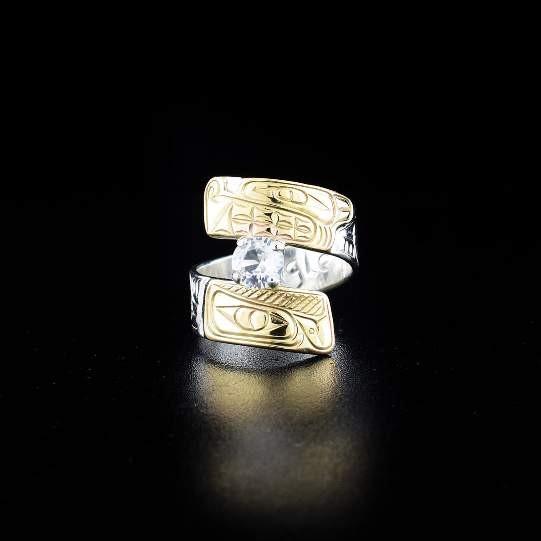 Eagle and wolf wrap ring hand-carved by Coast Salish and Cree artist Richard Lang. Made of sterling silver, 14K gold and a white sapphire. Band is 0.31" wide, with the flexible wrap design giving the ring a comfortable fit. Size 8.5.