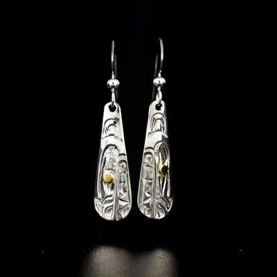 Long teardrop bear earrings hand-carved by Kwakwaka'wakw artist Carrie Matilpi. Made of sterling silver and 14K yellow gold. Each earring measures 1.55" x 0.40" including hook.